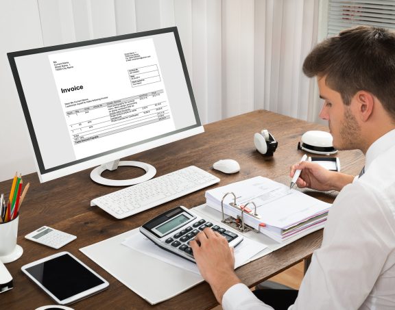 Accountant Calculating Tax At Desk